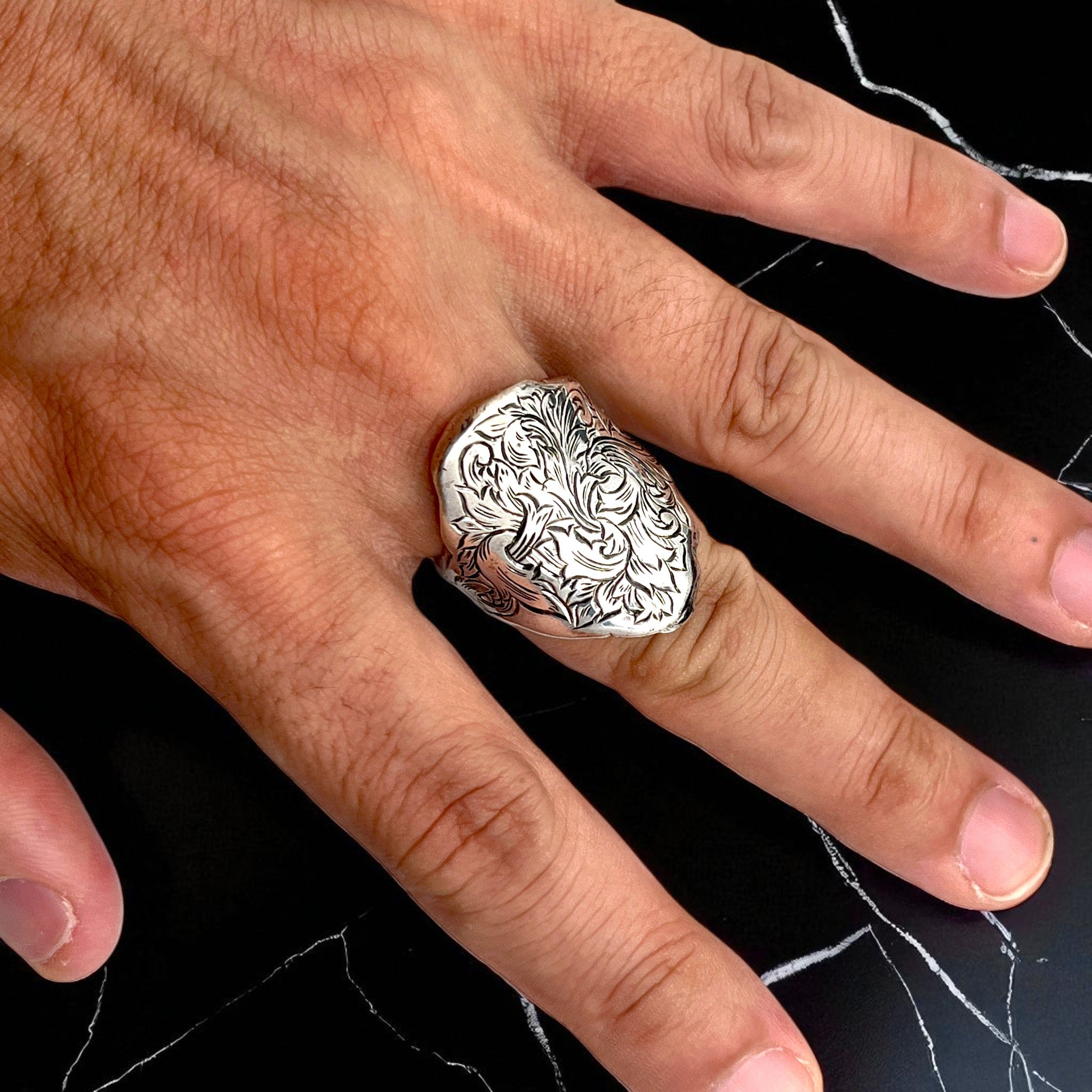 シルバーリング mythⅡ の着用写真。リング全面に繊細な植物模様をエングレービングで彫金し、存在感と重厚感を兼ね備えたデザインを映したイメージ。