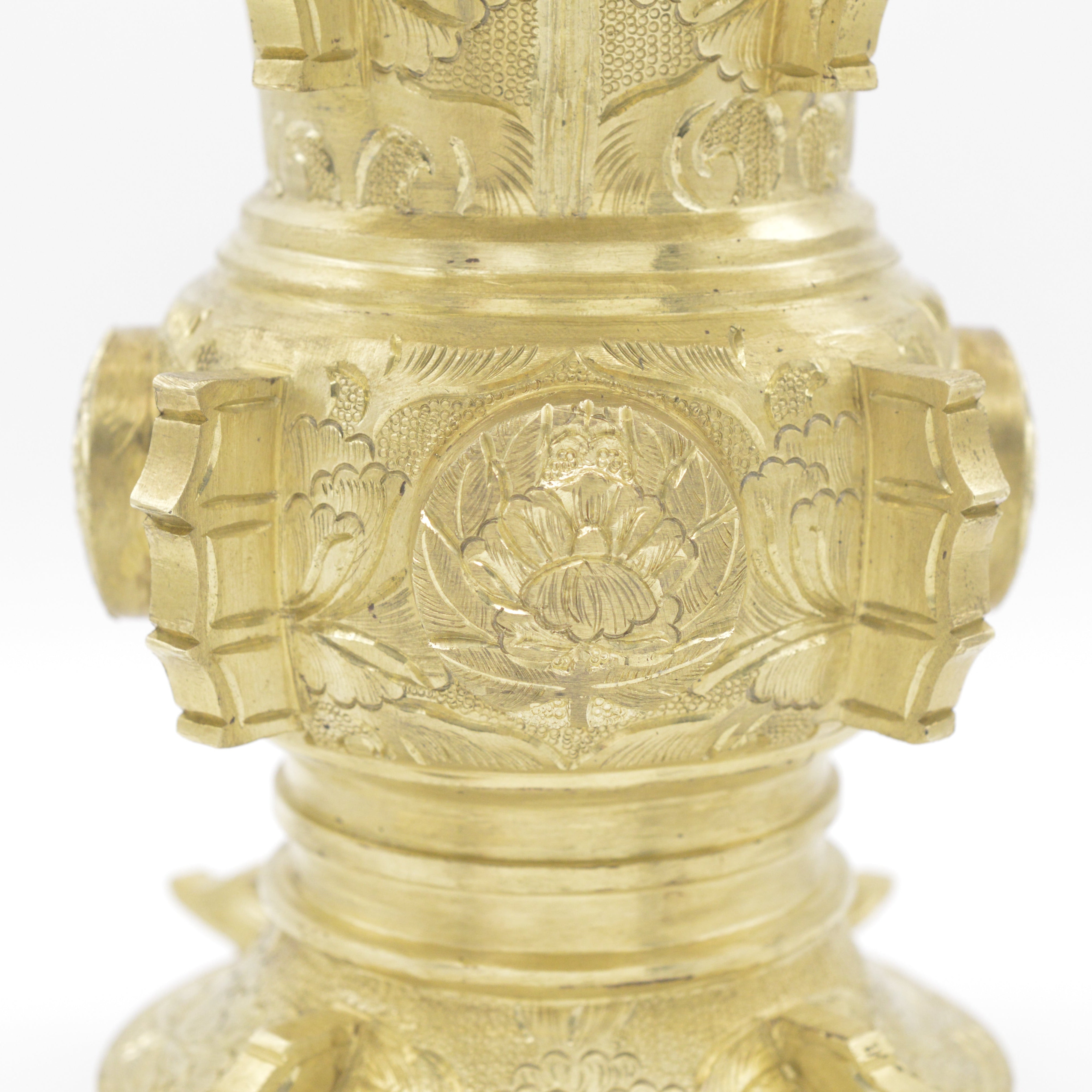 仏具の花立てに彫られた宗紋部分のクローズアップ。真鍮の表面に手彫り彫金で蓮の文様が精緻に刻まれている。