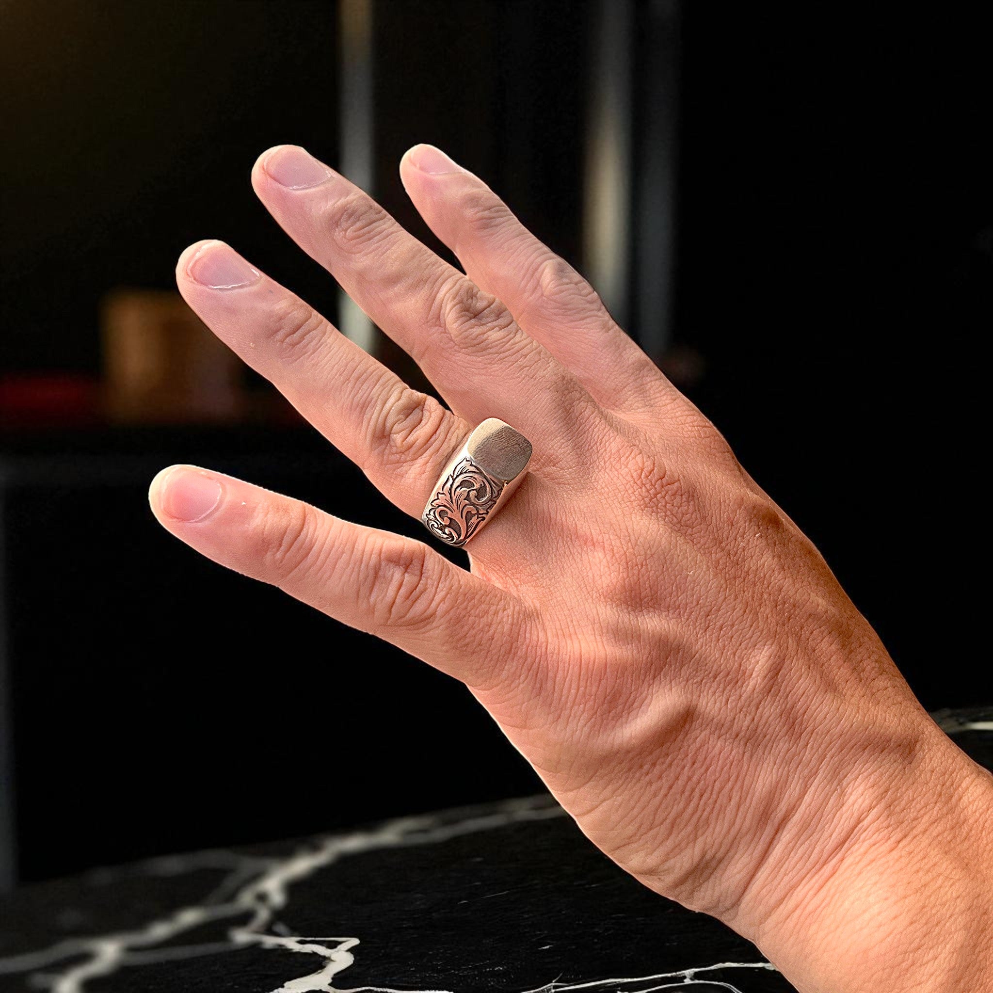 シルバーリング ivy の着用写真。シグネットリングの側面に植物模様を彫金し、正面は無地の鏡面仕上げでシンプルにデザインされた指輪。