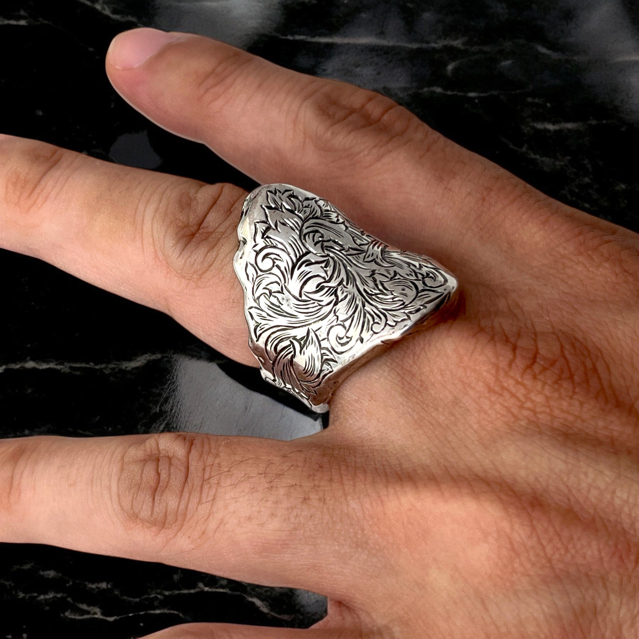 シルバーリング mythⅡ の着用写真。リング側面から天面にかけて繊細な植物模様をエングレービングで彫金し、流れるような唐草模様の立体感を映したイメージ。